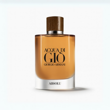 Acqua di Giò Absolu Eau de Parfum bottle by Giorgio Armani resting on a rock with ocean waves and a golden sunset background.