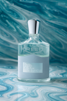 Creed Aventus Cologne bottle on marble blue background showcasing its sleek silver cap and elegant design