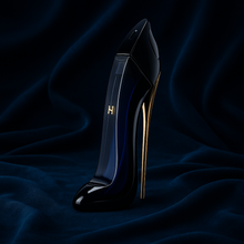 Good Girl Eau de Parfum bottle by Carolina Herrera on dark navy velvet background with elegant gold stiletto heel design