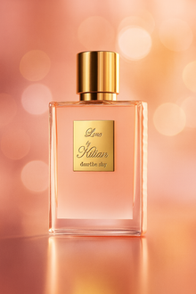 Kilian Love Don't Be Shy Eau de Parfum bottle on a soft pink and gold background, showcasing its elegant gold label and cap.
