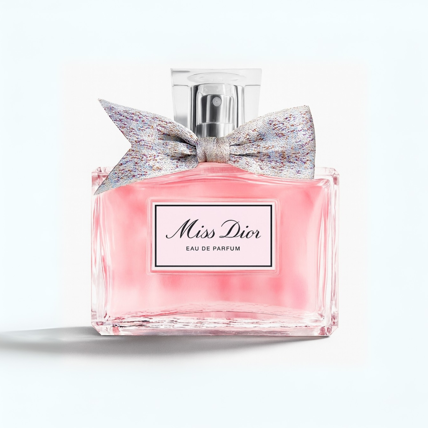 Miss Dior Eau de Parfum pink perfume bottle with silver fabric bow on a plain white background