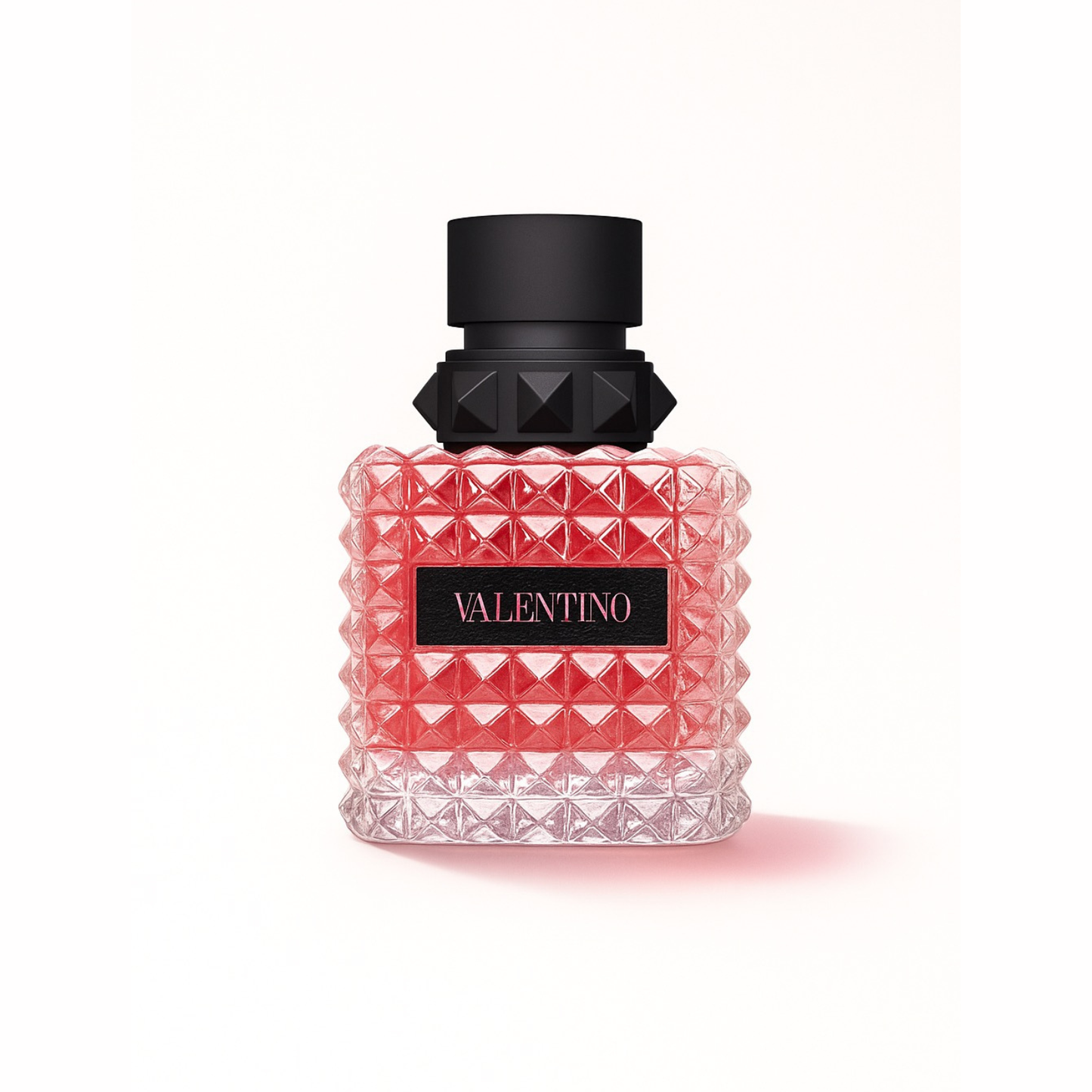 Valentino Donna Born In Roma Eau de Parfum bottle on white background showcasing its pink stud-patterned glass design and black cap with signature Valentino logo.