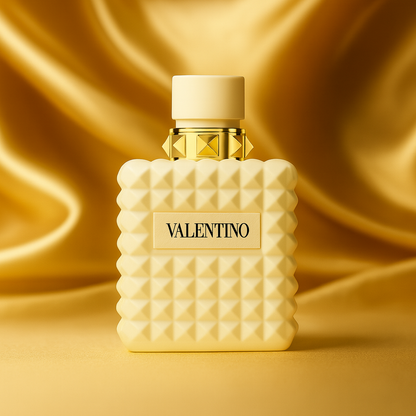 Valentino Donna Born in Roma Ivory perfume bottle with ivory studded design and gold accents displayed on gold satin fabric background