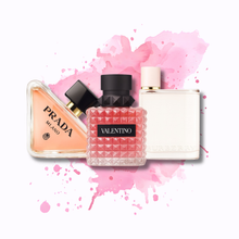 Women's Best Sellers Discovery Pack featuring Prada Paradoxe, Valentino Donna Born In Roma, and Burberry Her perfume bottles on a pink splash background